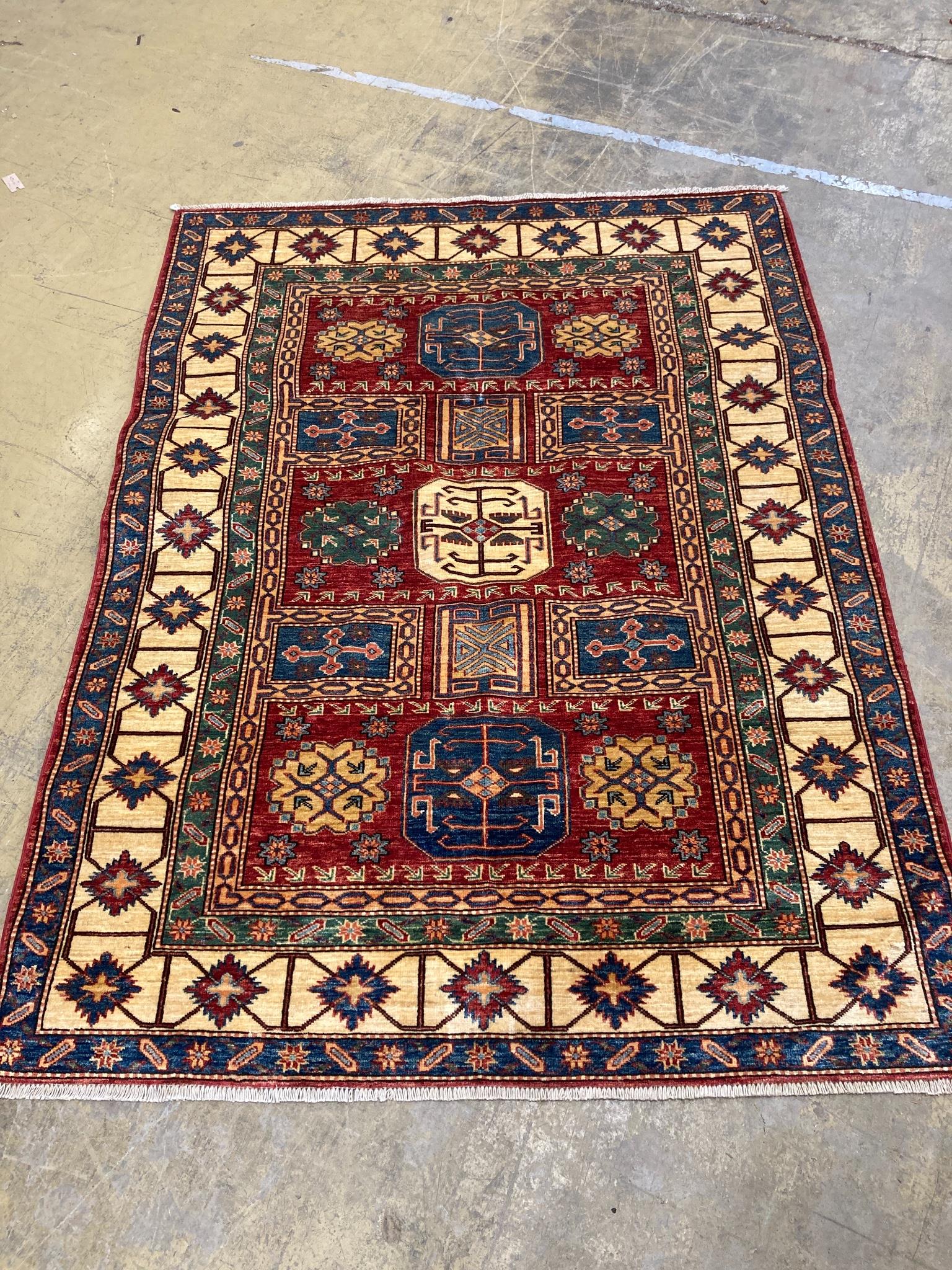 A Caucasian design red ground rug with geometric motifs within multi borders and guards, 200 x 150cm